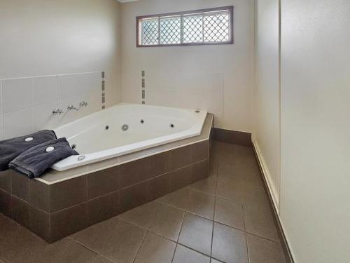 a large bathroom with a tub and a window at Outback Villas in Broken Hill