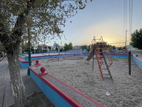 an empty playground with a play structure in the sand at Plácida casa cerca del consulado a 1500 metros del consulado americano in Ciudad Juárez