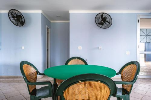 a green table and chairs in a room at Helbor Atlantis by Doce Lar de Bertioga in Bertioga