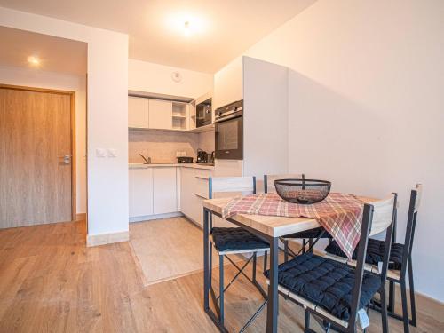 une cuisine et une salle à manger avec une table et des chaises dans l'établissement Appartement cosy 4* au pied des pistes avec WiFi et parking à Valmorel - FR-1-356-490, à Valmorel