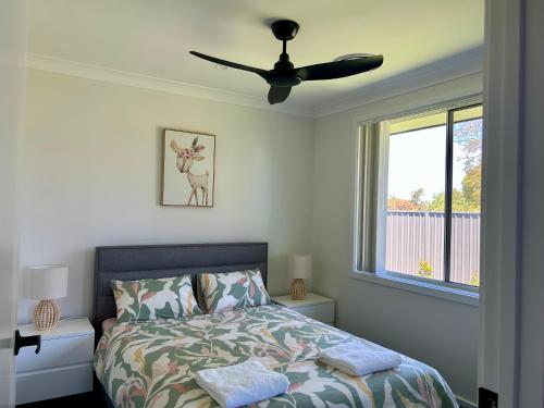 a bedroom with a bed and a ceiling fan at Paradise in Drysdale in Dubbo
