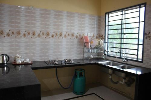 a kitchen with a sink and a water jug at Arau Pulau Hilir Home in Kampong Hutan Kandis
