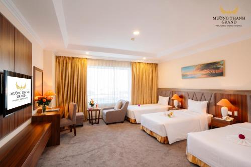 a hotel room with two beds and a flat screen tv at Muong Thanh Grand Phuong Dong in Vinh