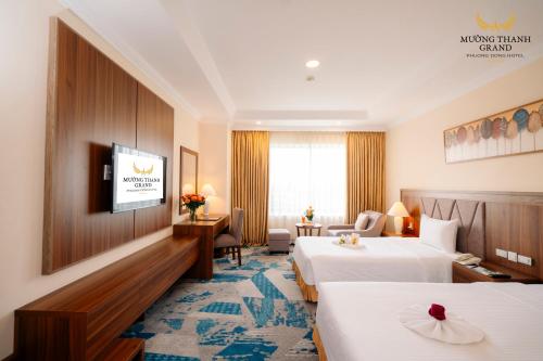 a hotel room with two beds and a television at Muong Thanh Grand Phuong Dong in Vinh