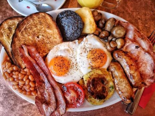 カットバ島にあるCat Ba Madame Duyen Hotelの卵ベーコン、豆を添えた朝食用の皿