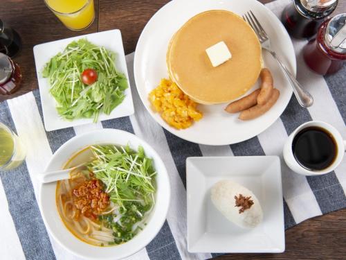 東京にあるアパホテル　上野広小路の食べ物の皿とコーヒーカップが置かれたテーブル