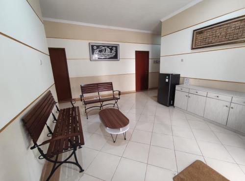 a waiting room with two benches and a refrigerator at Adiputra Guesthouse Tata Bumi by HomiQ in Ngabean