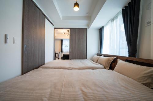 a bedroom with two beds and a window at MOXIE in Sapporo
