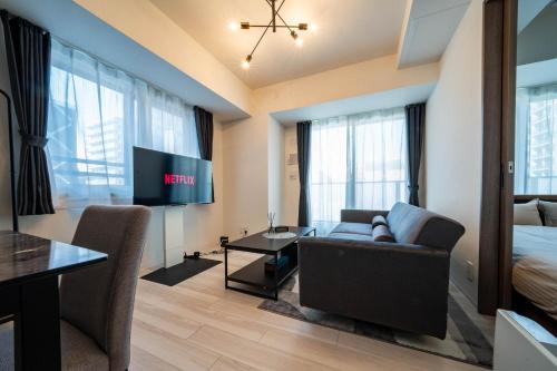 a living room with a couch and a tv and a bed at MOXIE in Sapporo