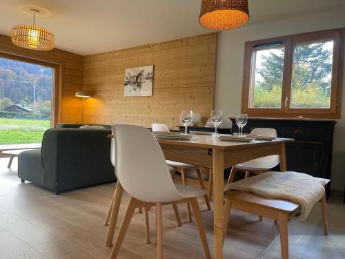 une salle à manger avec une table, des chaises et un canapé dans l'établissement Appartement moderne T4 avec jardin dans résidence neuve - FR-1-624-167, à Samoëns