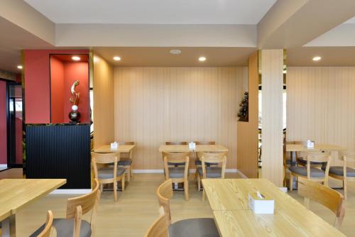 a dining room with wooden tables and chairs at Berich Hotel in Tak