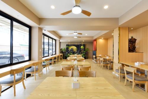 a restaurant with wooden tables and chairs and windows at Berich Hotel in Tak