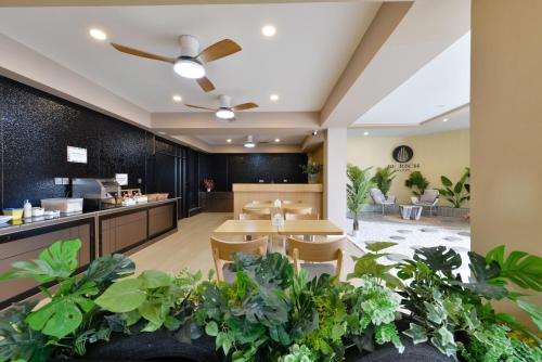 a restaurant with tables and chairs and plants at Berich Hotel in Tak