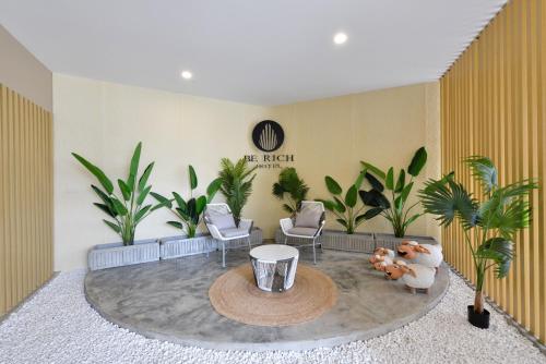 a waiting room with chairs and a table and plants at Berich Hotel in Tak