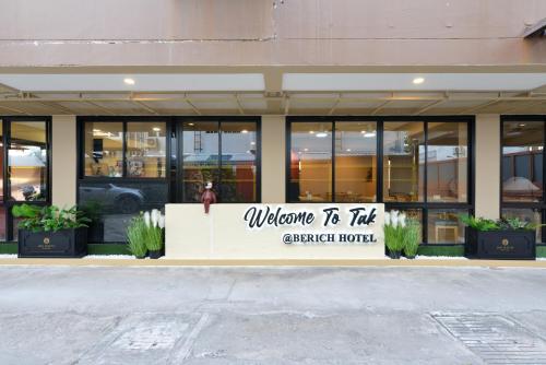 a store front with a welcome to the newest hotel sign at Berich Hotel in Tak