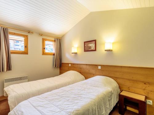 - une chambre avec deux lits et deux lumières sur le mur dans l'établissement Charmant duplex 2 pièces, 4 pers., balcon, casier à skis - La Plagne - FR-1-353-146, à La Plagne Tarentaise