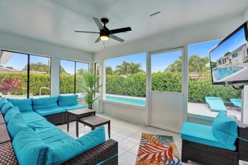 a living room with a blue couch and a flat screen tv at Coastal Breeze Retreat in Pembroke Pines