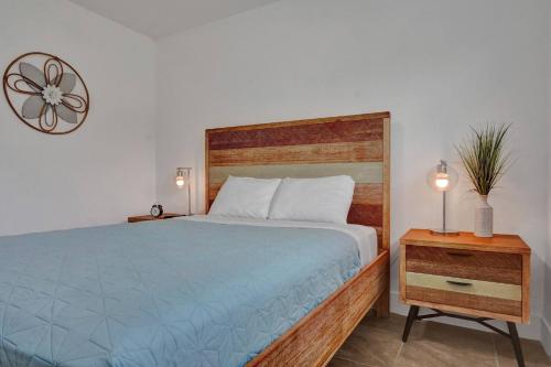 a bedroom with a bed with a wooden headboard and a table at Coastal Breeze Retreat in Pembroke Pines
