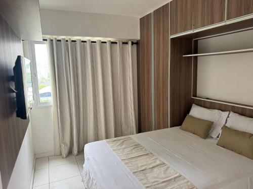 a bedroom with a large bed with a window at RioStay Apart com varanda em frente Riocentro Farmasi Arena Parque Olímpico Globo Projac in Rio de Janeiro