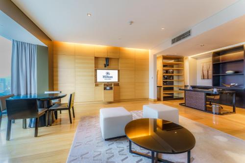 a living room with a table and a dining room at Hilton Kuala Lumpur in Kuala Lumpur