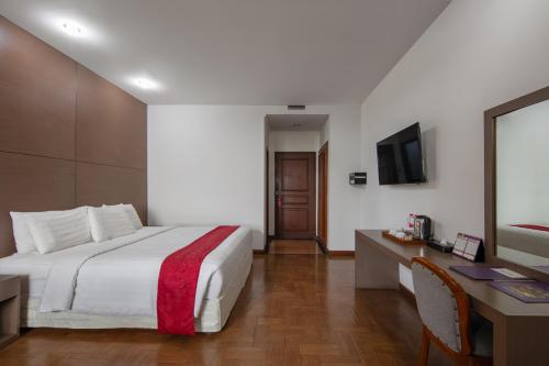 a hotel room with a large bed and a desk at Sinabung Hills Berastagi in Berastagi