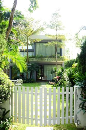 a white fence in front of a house at Flamigo Dai Lai Resort - Villa Chủ Tự Doanh in Ngọc Quang