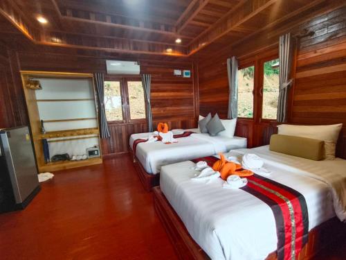 a bedroom with two beds with orange flowers on them at Kohjum Seafront Resort in Ko Jum