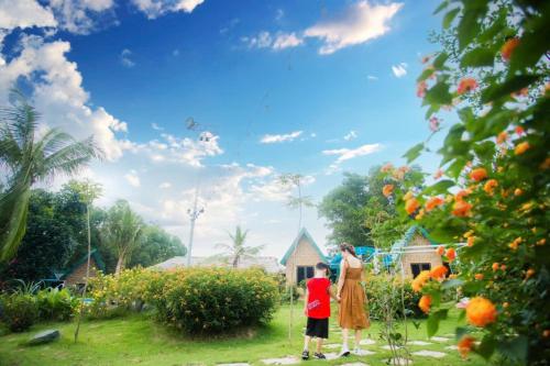 a woman and a child flying a kite in a garden at Rafe Garden-Homestay Ba Vì in Ba Vì