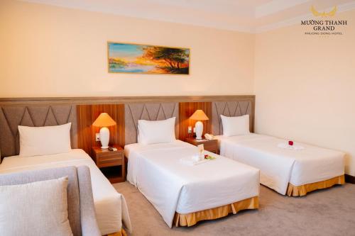 a hotel room with two beds with white sheets at Muong Thanh Grand Phuong Dong in Vinh