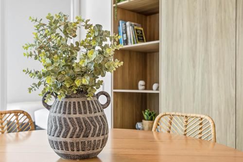 a vase with a plant sitting on a table at Waterfront 2-Bed Oasis - Pool Steam Jacuzzi Gym in Kawana Waters