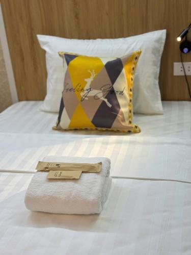 a towel sitting on top of a bed with a pillow at Opera Hostel in Hanoi