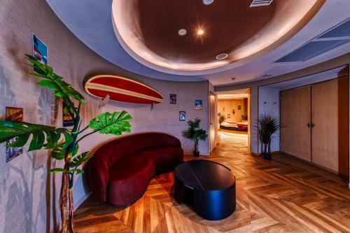 a living room with a couch and a surfboard on the wall at HOTEL ATLANTIS OARAI -Adult Only in Oarai