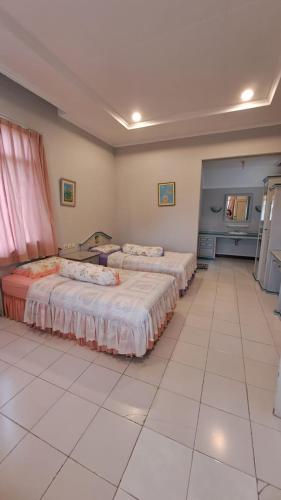 a room with three beds and a tiled floor at Alabare Puncak in Pasakon 1