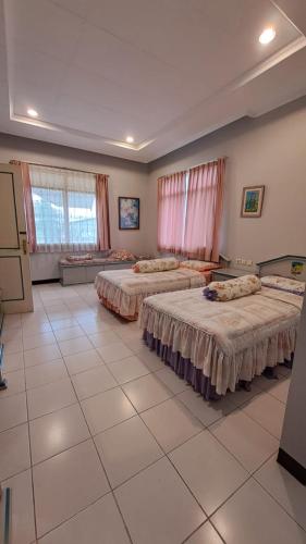 a large room with three beds in it at Alabare Puncak in Pasakon 1