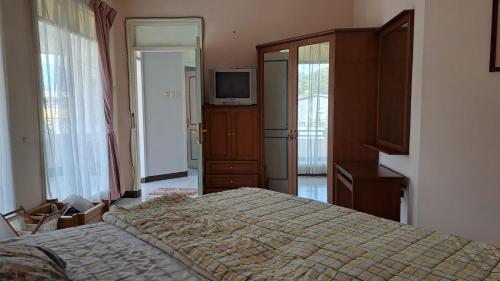 a bedroom with a bed and a television in it at Alabare Puncak in Pasakon 1
