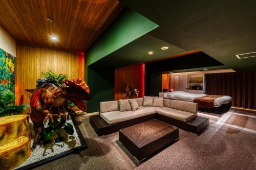 a living room with a couch and a bed at HOTEL ATLANTIS OARAI -Adult Only in Oarai
