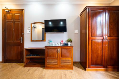 a room with a tv and a wooden cabinet at CAMY Hotel Vung Tau in Vung Tau
