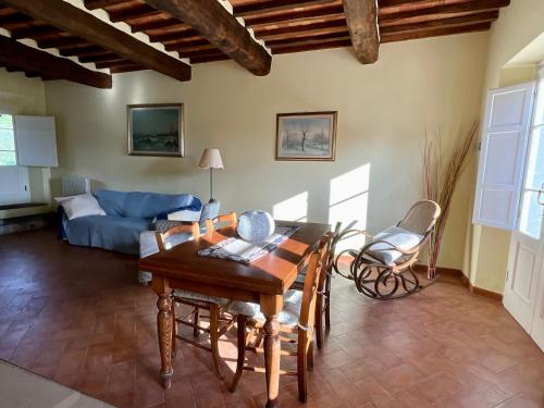 a living room with a table and a blue couch at Ringo, the true Tuscany Country House in Capannori