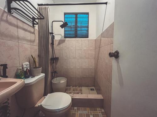 a bathroom with a toilet and a sink at Full AC 3BR & Living Rm entire vacation home at Vigan City in Barraca