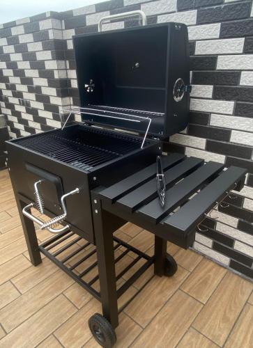 a barbecue grill sitting on a cart with wheels at 大溪漁港蜜月灣Luna民宿2號館 in Toucheng