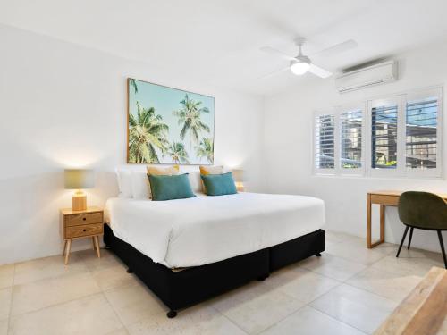 una camera da letto con un letto grande e una scrivania di Noosa Views 4 Noosa Drive 33 Stylish Coastal Retreat a Noosa Heads