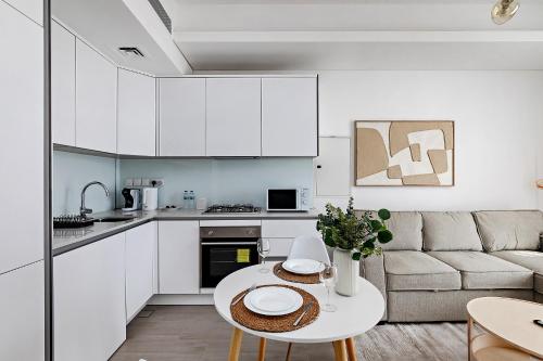 a kitchen and living room with a table and a couch at Bright 1BR with balcony in Luma 22 in Dubai