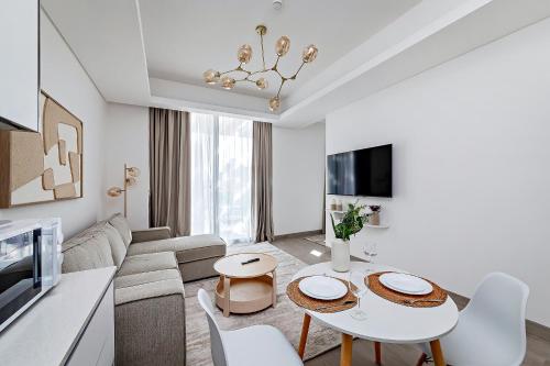 a living room with a couch and a table at Bright 1BR with balcony in Luma 22 in Dubai