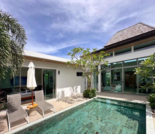 a villa with a swimming pool and a house at Lada Pool Villa in Bang Tao Beach