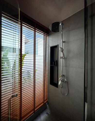 a bathroom with a shower and a window with blinds at Lada Pool Villa in Bang Tao Beach