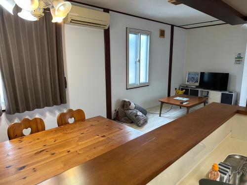 a living room with a large wooden table and chairs at 森の仲間たち in太子橋 1 丁目 in Osaka