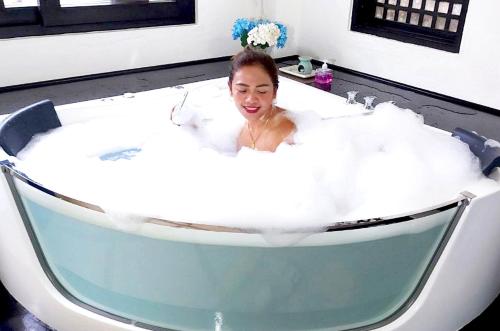 a woman in a jacuzzi bathtub at Out of the Blue Resort in Puerto Galera