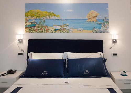 a bedroom with a bed with a painting above it at Villa Marinella in Ischia
