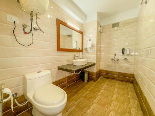 a bathroom with a toilet and a sink at Sparsh Resort, A Boutique Stay - Just 2kms uphill from Mall Road, near Old Manali in Manāli