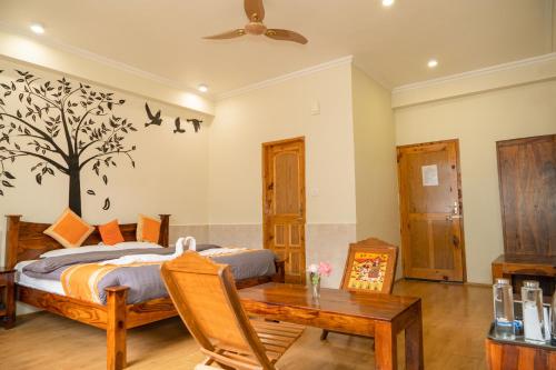 a bedroom with a bed with a tree on the wall at Sparsh Resort, A Boutique Stay - Just 2kms uphill from Mall Road, near Old Manali in Manāli